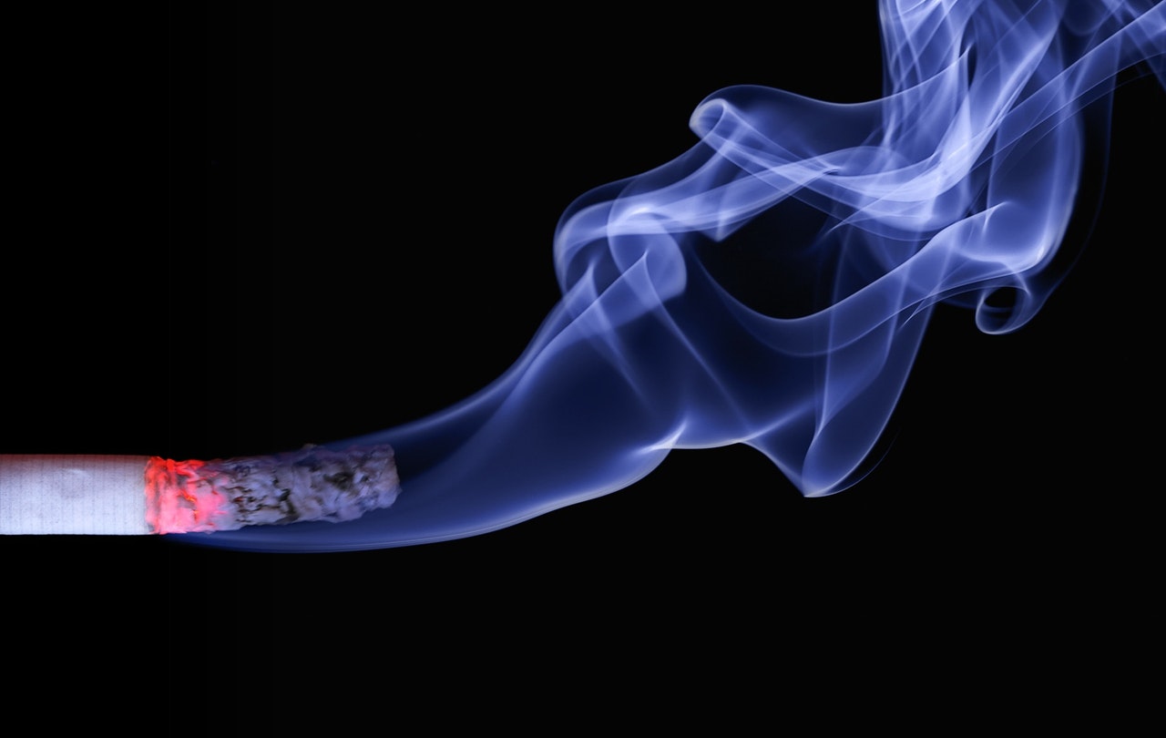 half-burnt cigarette with ashes and smoke
